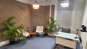 Wide view of the University of Greenwich podcast studio showing the podcast seating area, lecture capture space and production lighting.