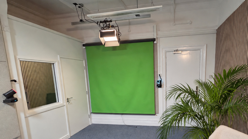 Green-screen video production area at the University of Greenwich, showing the pull-down chroma-key background and studio lighting.